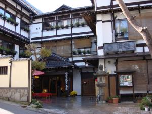 a building with a courtyard in front of it at Ekinariya Ryokan in Kusatsu