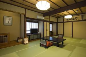 a living room with a ping pong table in it at Ekinariya Ryokan in Kusatsu