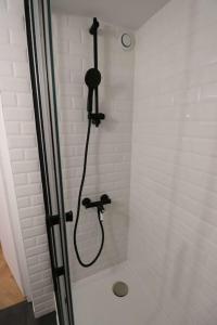La salle de bains est pourvue d'une douche avec un pommeau de douche noir. dans l'établissement Cocon neuf & cosy - A deux pas de Bercy, à Paris