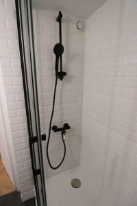 a shower with a black shower head in a bathroom at Cocon neuf & cosy - A deux pas de Bercy in Paris