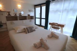 ein Schlafzimmer mit einem großen weißen Bett mit zwei Kissen in der Unterkunft Cocon neuf & cosy - A deux pas de Bercy in Paris