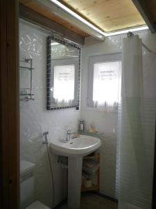 y baño blanco con lavabo y ducha. en Villetta da Carla en Castellón de Ampurias