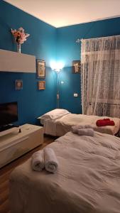 a bedroom with two beds and a blue wall at Colombo Holidays APT in Rome