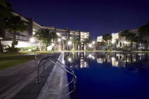 a building with a swimming pool at night at Apto de diseño Salou-piscina gym in Salou