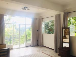 a living room with large windows and a balcony at Sithara Estate Bungalow in Ella