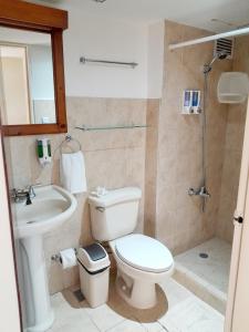 een badkamer met een toilet, een wastafel en een douche bij Family condo, pool, beach and surf in Jacó