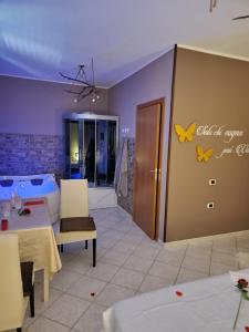 Andale SuiteSpa في Villa Badessa: غرفة معيشة مع طاولة وحوض استحمام