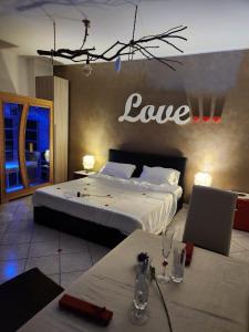 een slaapkamer met een bed met een liefdesbord aan de muur bij Andale SuiteSpa in Villa Badessa