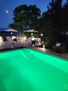 een groen zwembad in een achtertuin 's nachts bij Andale SuiteSpa in Villa Badessa