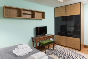 a bedroom with a bed with a desk and a television at East Wing in Bristol