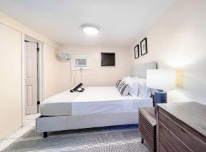 a white bedroom with a bed and a lamp at Seaside Studio: Cruz Bay Gem in Enighed