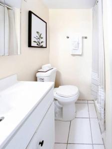 a white bathroom with a toilet and a sink at Seaside Studio: Cruz Bay Gem in Enighed