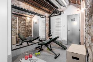 a gym with two green chairs and a mirror at Luxury apartment in the center in Prague