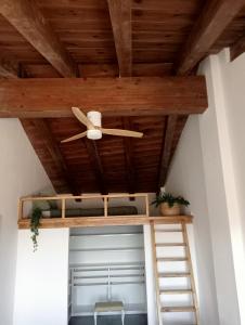 Habitación con ventilador de techo y techo de madera. en CASA RURAL ALEGRE, en La Fresneda