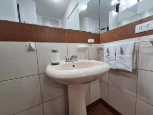 ein weißes Badezimmer mit einem Waschbecken und einem Spiegel in der Unterkunft Habi baño Compartido Grimaldo 1 in Lima