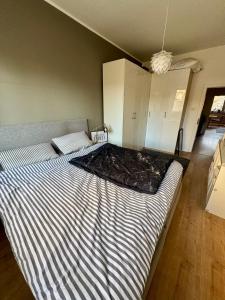 ein Schlafzimmer mit einem großen Bett und einer gestreiften Decke in der Unterkunft Wohnung Apartment Düsseldorf zentral in Düsseldorf