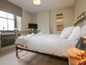 a bedroom with a bed with white sheets and a window at 4 Castle Terrace in Barnard Castle