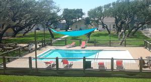 una piscina con una hamaca en un patio en Sea-la-vie - Coastal Cottage With Community Pool, en Rockport