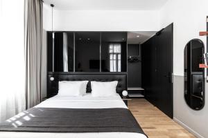 a bedroom with a large bed with a black headboard at The Modernist Thessaloniki in Thessaloniki