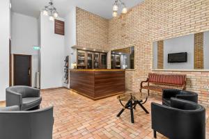 a lobby with chairs and a bar in a brick wall at Unio Apartment in Budapest