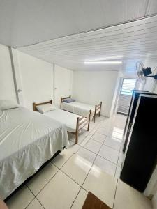 um quarto com duas camas e uma televisão em Pousada Alojamento AS em Viracopos