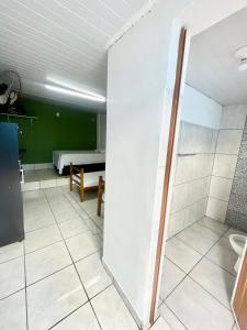 uma casa de banho com um chuveiro e um quarto com uma cama em Pousada Alojamento AS em Viracopos