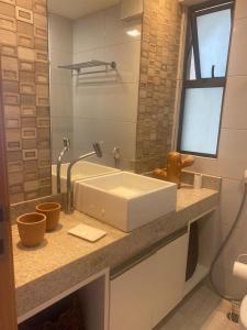 a bathroom with a white sink and a shower at Polinesia Resort - Porto de Galinhas - Apartamentos com somente 1 opção de Térreo com Piscina Privativa - Acesso ao Hotel Samoa in Porto De Galinhas