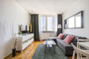 ein Wohnzimmer mit einem Sofa und einem TV in der Unterkunft Pańska Residence in Warschau