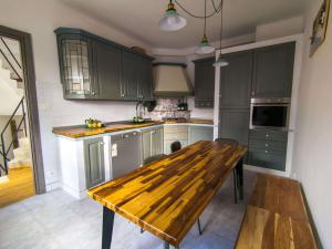 a kitchen with green cabinets and a wooden table at La casetta del prato in Iesi
