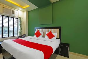 - une chambre avec un grand lit et des oreillers rouges dans l'établissement OYO Flagship Hotel Abhinandan, à Kanpur
