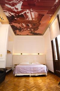 a bedroom with a bed with a painting on the ceiling at Loft Osteria by Sagardi in Buenos Aires