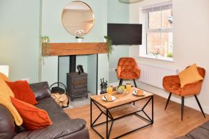 un soggiorno con divano e camino di Village Life, cosy yet spacious home a Oswestry