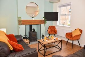 a living room with a couch and a fire place at Village Life, cosy yet spacious home in Oswestry