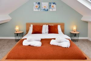 Village Life, cosy yet spacious home في أوسويستري: غرفة نوم عليها سرير وفوط