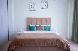 - une chambre avec un grand lit et des oreillers bleus dans l'établissement inJoy, à Sajmište