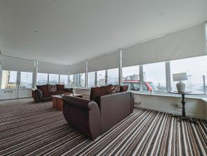 a living room with a couch and a table and windows at Bay & Harbour Holiday Apartments & rooms only in Weston-super-Mare