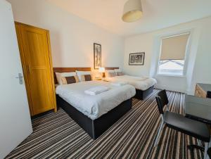 una habitación de hotel con 2 camas y un piano en Bay & Harbour Holiday Apartments & rooms only, en Weston-super-Mare
