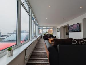 ein Wohnzimmer mit Sofas und Fenstern in einem Gebäude in der Unterkunft Bay & Harbour Holiday Apartments & rooms only in Weston-super-Mare