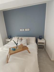 a bedroom with a white bed with a table on it at Appartamenti Vacanze Villa Meo in Villafranca Tirrena