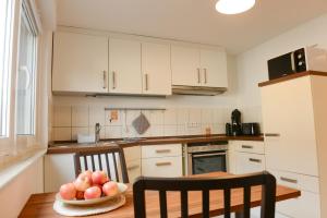 a kitchen with a table with a bowl of fruit on it at Ferienwohnung Malou in Tettnang