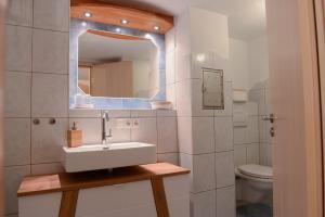 Baño blanco con lavabo y aseo en Ferienwohnung Malou, en Tettnang