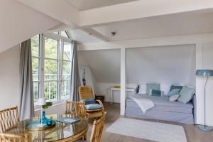 a bedroom with a bed and a glass table at Villa Hygiea - Boutiqueapartments am Wörthersee in Pörtschach am Wörthersee