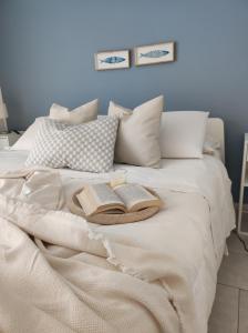 蒂雷納自由鎮的住宿－Appartamenti Vacanze Villa Meo，一张床上有两本书和两根蜡烛