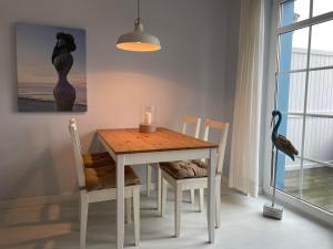 a dining room table with chairs and a candle on it at Meer and Mehr in Zingst