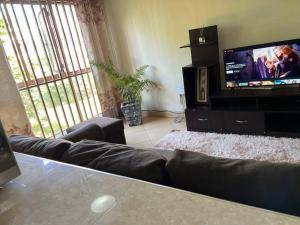 a living room with a couch and a flat screen tv at MD comfort living in Kampala