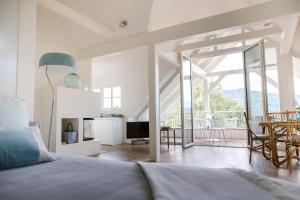 a bedroom with a bed and a living room with a balcony at Villa Hygiea - Boutiqueapartments am Wörthersee in Pörtschach am Wörthersee