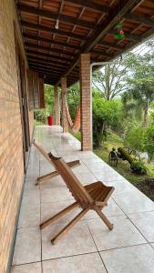 une chaise en bois assise sur une terrasse dans l'établissement Sítio com piscina incrível, à Santo Amaro da Imperatriz
