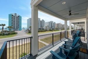 a balcony with two blue chairs and a view of the ocean at Newly Built, Luxury Home w/ pool & beach access in Gulf Shores