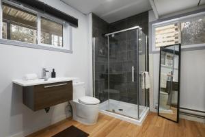a bathroom with a shower and a toilet and a sink at The Nordic 2BR Chalet by Instant Suites - 5 min to Tremblant Village in Mont-Tremblant