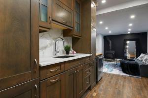 a kitchen with a sink and a living room with a couch at The Nordic 2BR Chalet by Instant Suites - 5 min to Tremblant Village in Mont-Tremblant